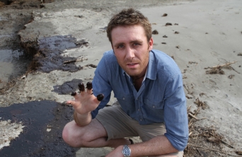 Philippe Cousteau shows oil on his fingertips during the BP Oil Spill.